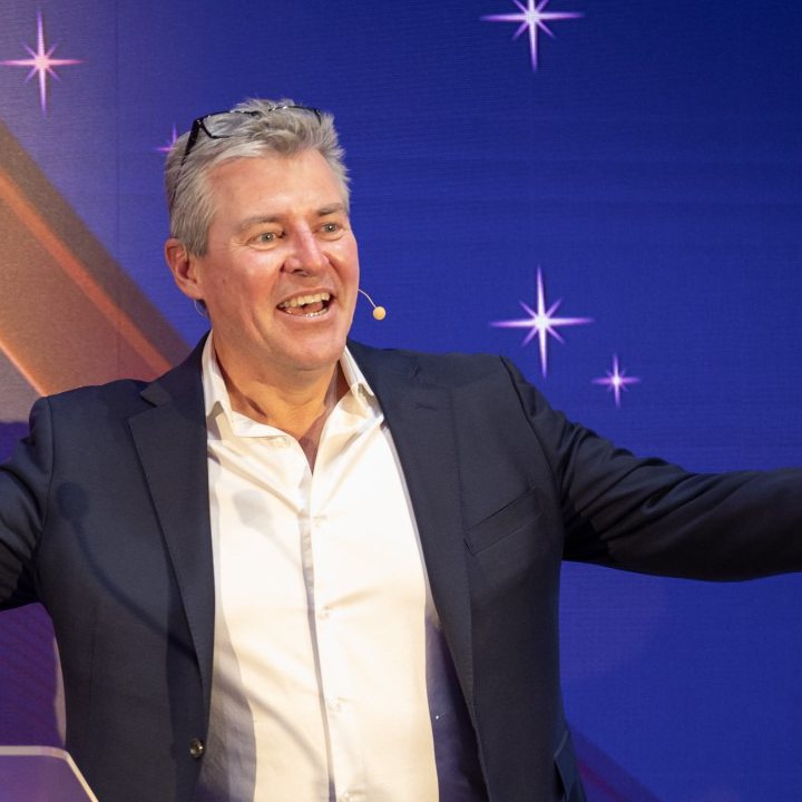 Michael Teulon laughing on stage at an awards night
